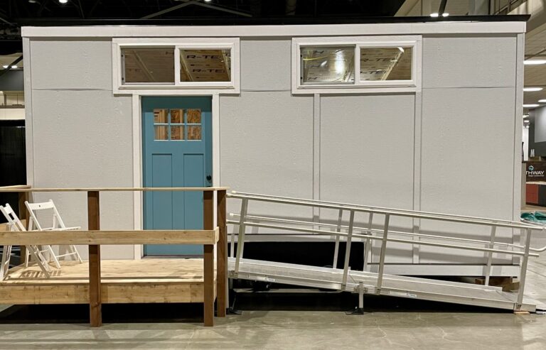20' value travel trailer painted gray with blue door.